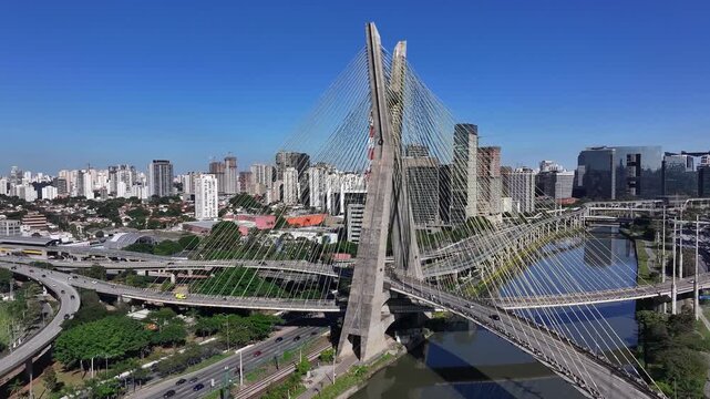Aerial view of Oct&aacute;vio Frias de Oliveira Bridge over the Pinheiros River in S&atilde;o Paulo, Brazil, with modern skyline and urban highways.
