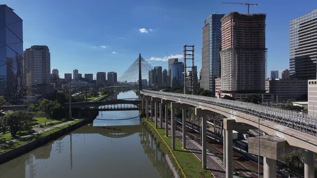 Aerial view of Oct&aacute;vio Frias de Oliveira Bridge over the Pinheiros River in S&atilde;o Paulo, Brazil, with modern skyline and urban highways.
