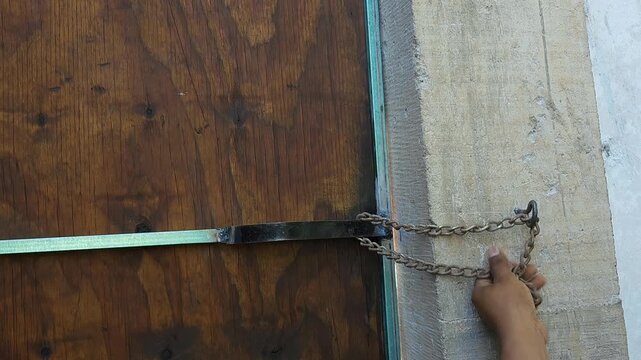 Securing a rustic wooden door with a small metal chain