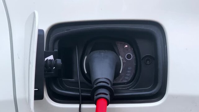 Electric car charge, EV Car or Electric vehicle at charging station with the power cable supply plugged in. Eco-friendly sustainable energy concept.