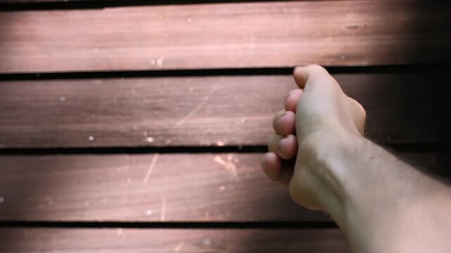 Neurodivergent hand stimming against wooden surface