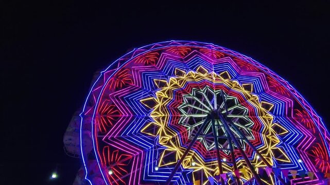 A Ferris wheel with colorful lights at night with copy space, part 4