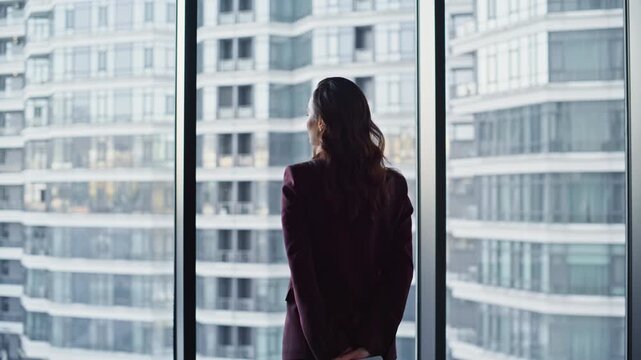 Thoughtful woman standing big window hall back view. Businesswoman thinking idea