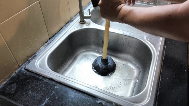 The process of repairing a kitchen sink that's clogged with food scraps and dishwashing. Poorly maintained kitchen sink hygiene can lead to clogged sinks.