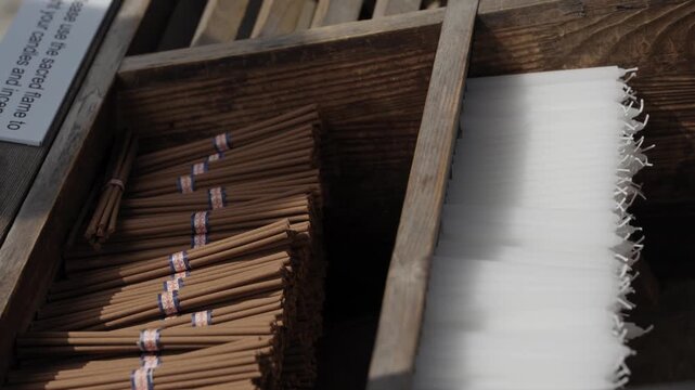 Bundled incense sticks in wooden box for offering at Buddhist temple in Japan