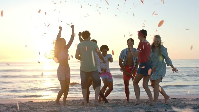 Group of seven adults dancing on beach at sunset, petals falling around group sparking event promo