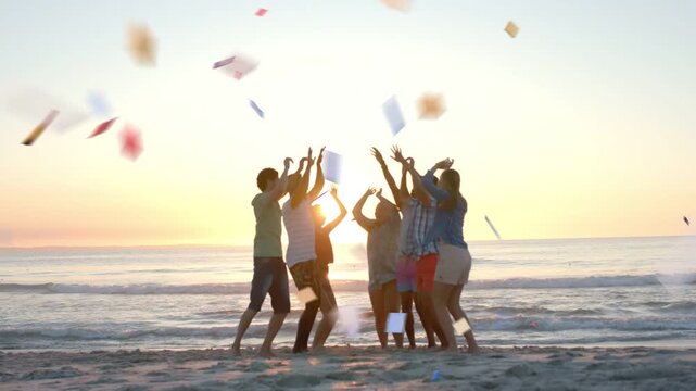 Five friends raising arms and tossing confetti on beach at sunset, creating event marketing content