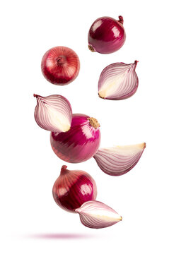 Explosion of whole red onions and fresh purple onion slices falling in the air. Natural organic vegetable ingredients isolated on white background.