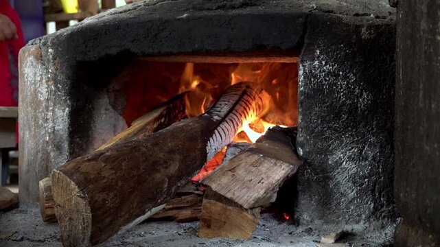 Close up view of burning firewood inside a traditional wood fired stove, highlighting heat, flame and rustic cooking methods in Oaxaca, Mexico