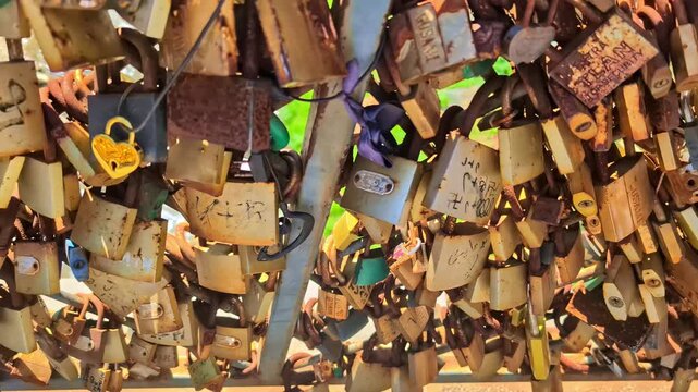 Thousands of weathered love locks hanging on a fence as a symbol of eternal love and commitment