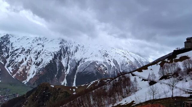 Gergeti Trinity Church overlooking the village of Stepantsminda in the snow