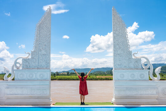 Female tourist standing at the naga gate an iconic tourist attraction in Wat Pa Yang Sob Yab temple in Chiang Saen district of Chiang Rai province of Thailand.