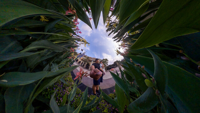 Father and daughter exploring tropical garden with unique perspective