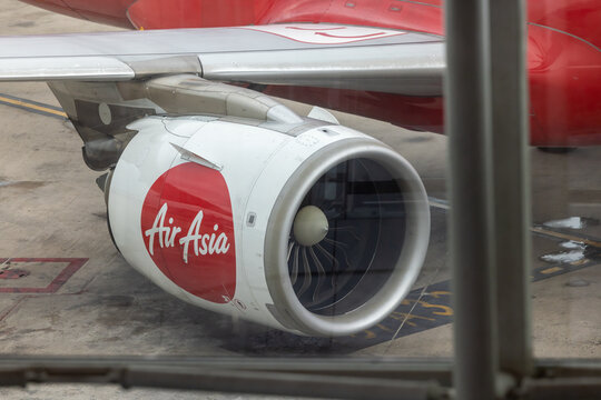 Airasia airplane turbine engine viewed from airport terminal window
