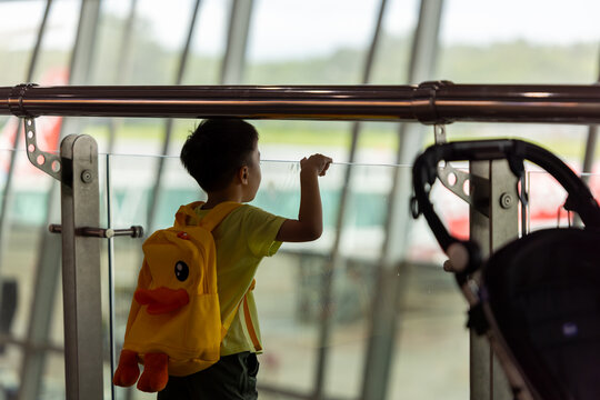 Little girl running on moving walkway in airport terminal