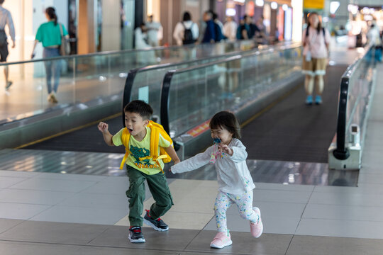 Happy children running in airport terminal while traveling