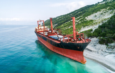 Obraz premium Aerial view of an abandoned bulk-carrier dry cargo ship washed ashore after a storm