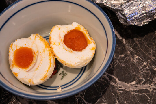 Salted duck egg halves in bowl showing orange yolk