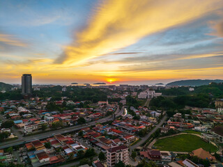 Fototapeta premium Aerial view of Kota Kinabalu city at sunset, Sabah, Malaysia, with vibrant golden sky.