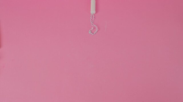 Video Stop Motion of White sanitary tampon moving on bright pink background