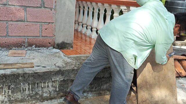 Young man using a manual wire brush on an mdf wood surface