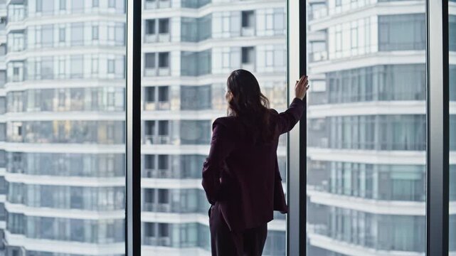 Confident leader standing panoramic office window thinking on business success