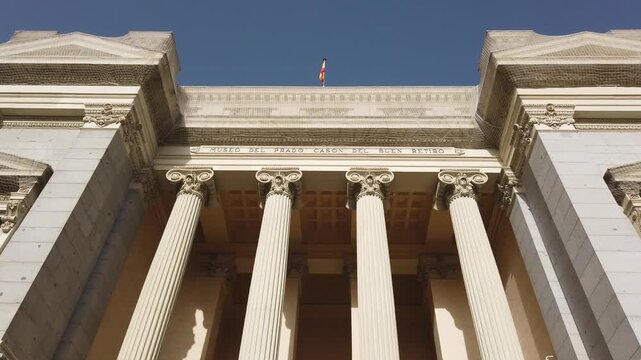 Low Angle Tilt Down of Cas&oacute;n del Buen Retiro Neoclassical Columns and Spanish Flag Madrid Spain