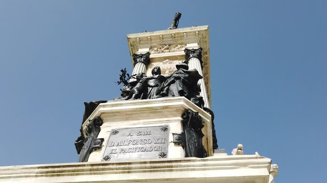 Low Angle Tilt Up of Alfonso XII Monument Pedestal and Bronze Sculptures Madrid Spain