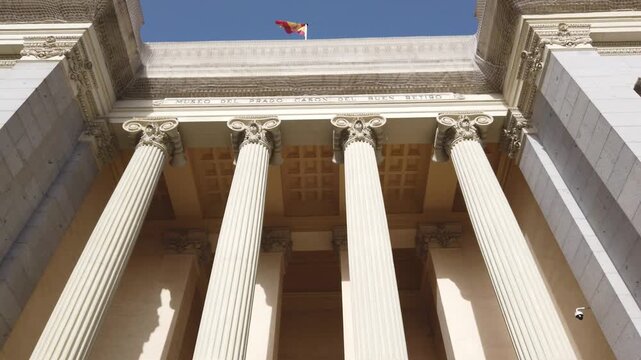 Madrid Spain Low Angle Tilt Up View of Cas&oacute;n del Buen Retiro Neoclassical Facade Columns and Spanish Flag