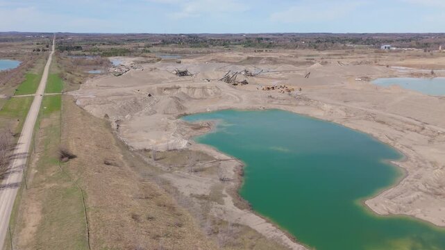Calm Quarry Lake With A Gravel Spit In The Background Near Caledon Village, Ontario, Canada. Aerial Drone Shot