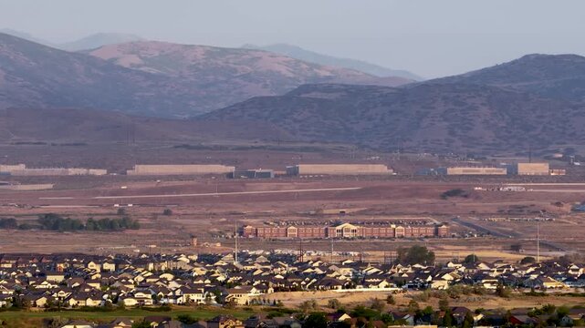 Lehi, Utah with Camp Williams and the NSA Data Center at the foot of the Oquirrh Mountains - sliding aerial view on a hazy day