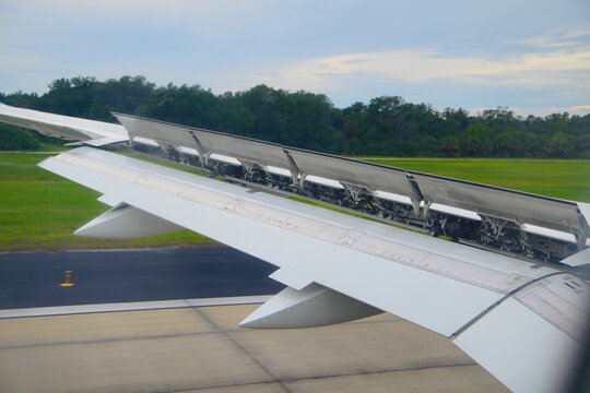 fully deployed spoilers (or speed brakes) on the top surface of a commercial airplane wing immediately after landing
