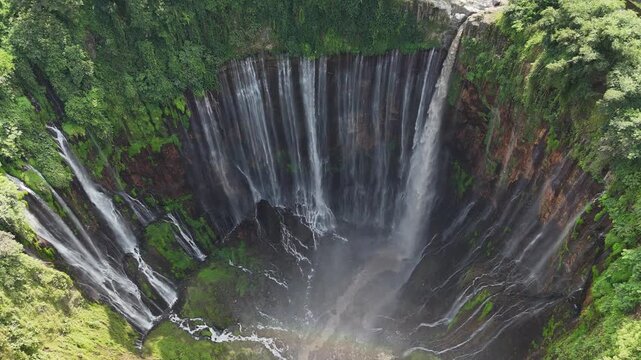 Aerial view of Tumpak Sewu waterfall is one of the most stunning waterfalls in Indonesia, standing at 120 meters tall with the most insane panorama view.