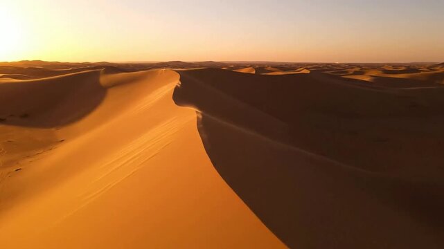 Golden hour desert sand dunes aerial view, vast sahara landscape at sunset