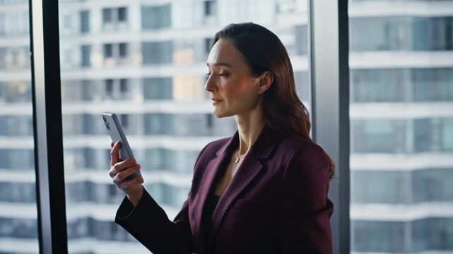Professional tapping mobile phone at panoramic window closeup. Successful woman