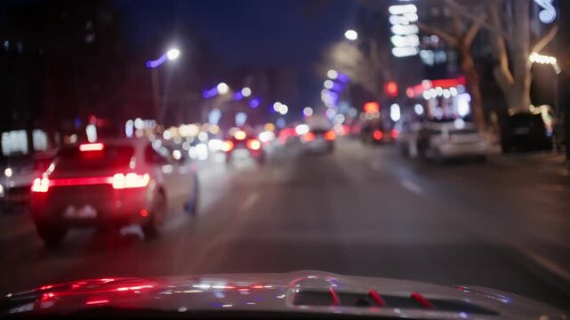 Driving car on night street in city with traffic jam and blurred bokeh car light and street light.