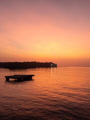 Serene sunset reflecting golden light over calm ocean © Hector Pertuz