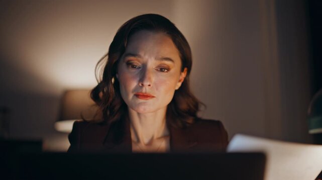 Overloaded employee reviewing documents at night workplace closeup. Tired woman