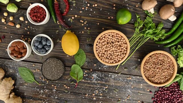 Healthy ingredients laid out on rustic wooden table diverse selection of superfoods and vegetables.