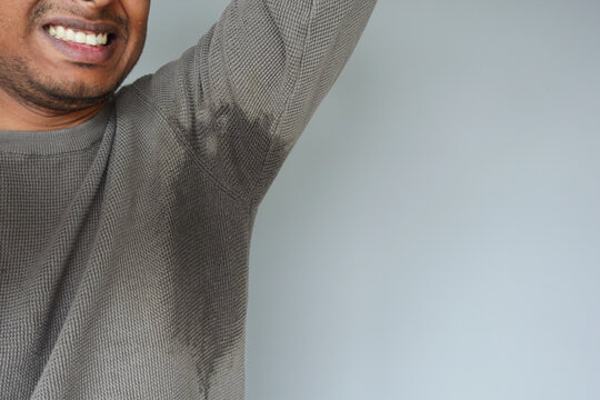 Sweaty individual showing underarm dampness during day