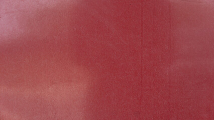 Fototapeta premium Background texture displaying a solid dark red painted wooden plank surface. The matte finish features subtle gradients and soft lighting across the plain area.
