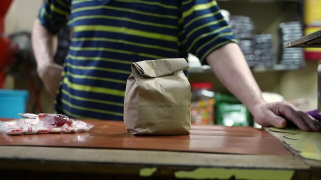 Shopkeeper packing old fashioned candy into paper bag