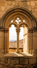 Fototapeta premium Historic Gothic Window Arch with Stone Detailing and Scenic View.