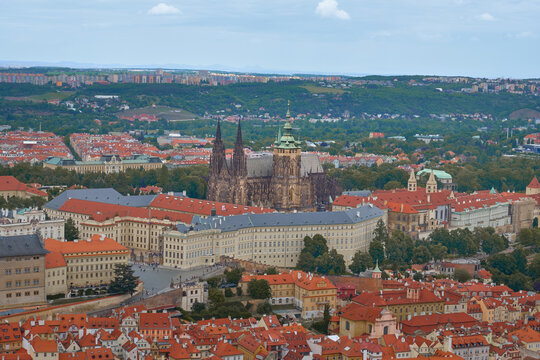 Stunning panoramic view of Prague Castle (Prazsky hrad) and St. Vitus Cathedral overlooking the historic city center with traditional red roofs.
