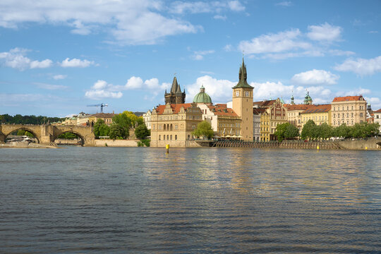 Riverside view of the Old Town Water Tower and the Smetana Embankment buildings along the Vltava River in Prague.