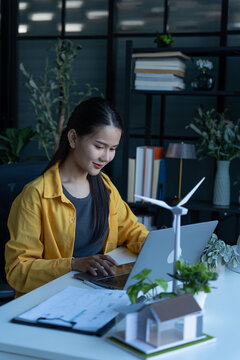 Engineer holding light bulb with laptop green energy concept