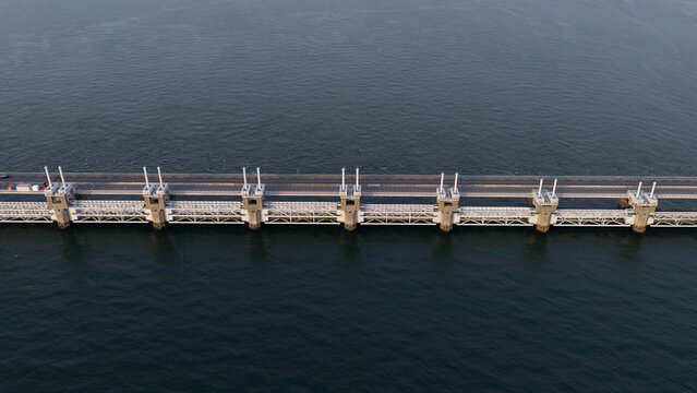 Aerial view of the Eastern Scheldt Storm Surge Barrier spanning the water, showcasing its massive concrete piers and steel gates in Vrouwenpolder, Zeeland, Netherlands.