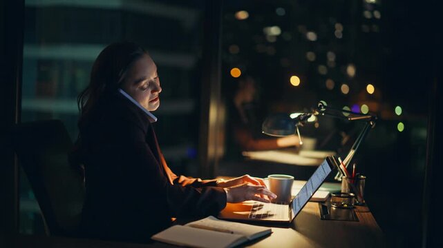Calling director laughing dark office sitting work desk with laptop closeup
