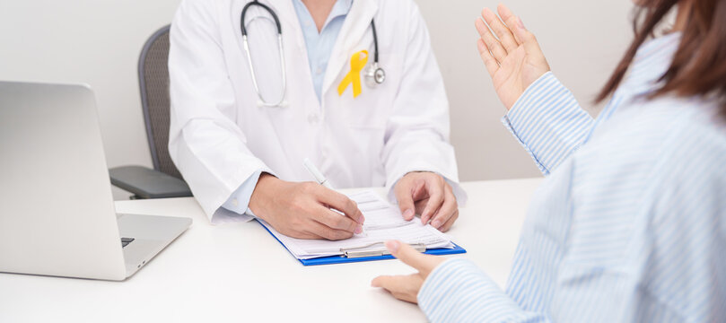 Doctor and patient having a medical consultation for Yellow Ribbon concept of yellow September, Suicide prevention day, Childhood, July Sarcoma, bone and bladder cancer, explaining treatment plan