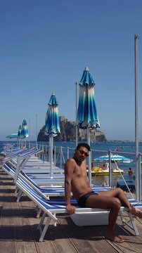 Male tourist enjoying a sunny summer day overlooking Castello Aragonese in Italy